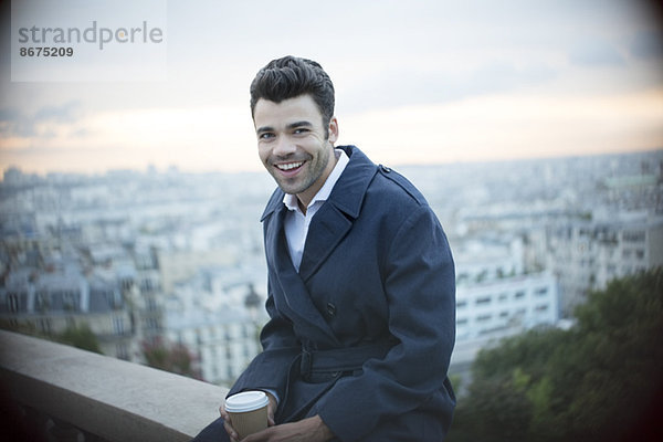 Geschäftsmann beim Kaffeetrinken auf dem Sims mit Blick auf Paris  Frankreich