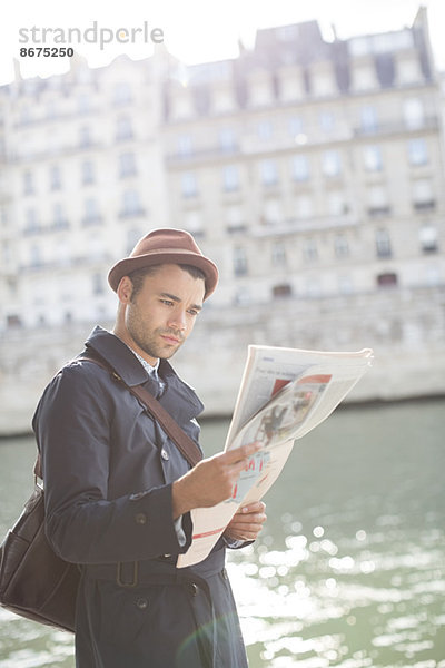 Geschäftsmann beim Zeitungslesen entlang der Seine  Paris  Frankreich