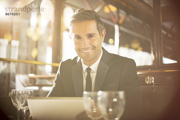 Mann mit digitalem Tablett im Restaurant