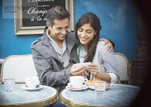 Paar mit Handy im Bürgersteigcafé  Paris  Frankreich