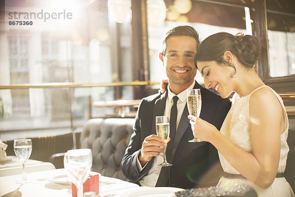 Gut gekleidetes Paar trinkt Champagner im Restaurant