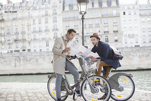 Männer auf Fahrrädern lesen Karte entlang der Seine  Paris  Frankreich