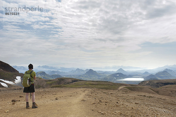 Trekking im Hochland  Frau mit weitem Ausblick in die Berglandschaft  Trekkingweg Laugavegur  bei See Álftavatn  Rangárþing ytra  Suðurland  Island  Skandinavien