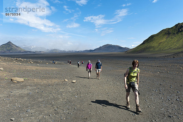 Trekking im Hochland  Wanderer gehen über vegetationslose Schotterfläche  Trekkingweg Laugavegur  hinten links Berg Storasula  Utigönguhöfðar bei Emstrur  Rangárþing ytra  Suðurland  Island  Skandinavien