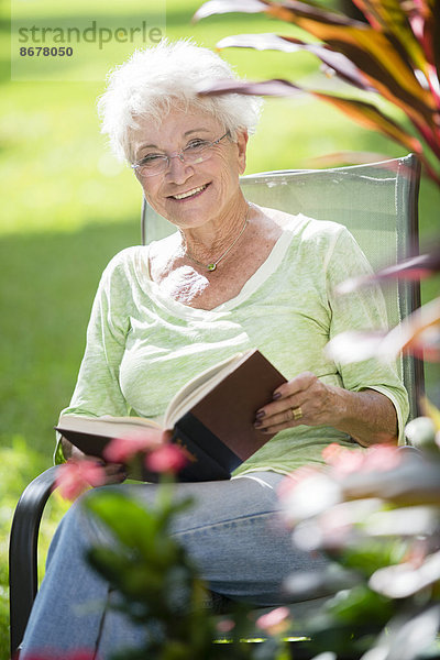 Außenaufnahme Senior Senioren Europäer Frau Buch Taschenbuch freie Natur vorlesen
