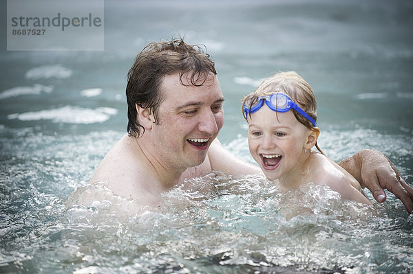 Ein Vater und sein Sohn in einem Schwimmbad  schwimmend.