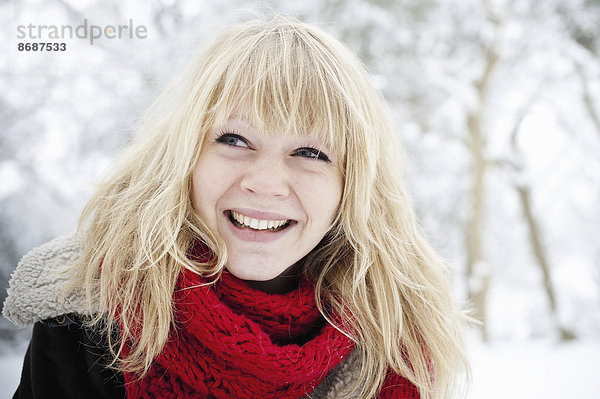 Eine junge Frau mit blonden Haaren im Schnee.