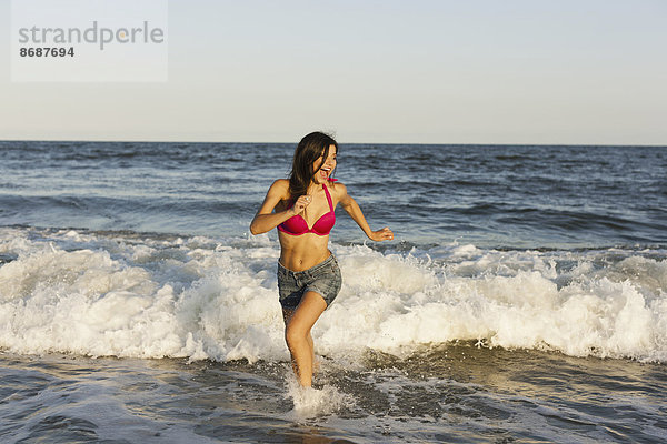 Eine schöne junge Frau am Wasser am Strand von Atlantic City.