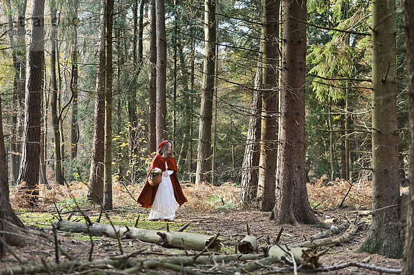 Mädchenmaskerade als Rotkäppchen im Wald unterwegs
