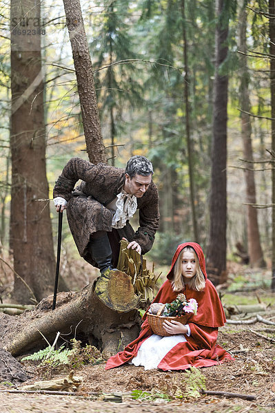 Mann  der das Wolfsbegegnungsmädchen verkleidet als Rotkäppchen repräsentiert.