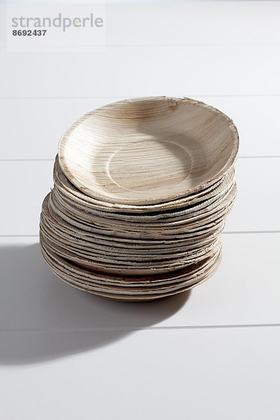 Stapel Palmblattplatten auf weißem Holztisch  Studioaufnahme
