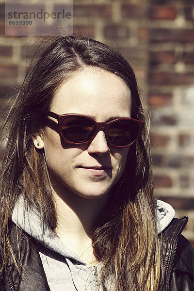 Porträt einer jungen Frau mit Holzsonnenbrille