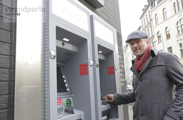 Man standing at cash dispenser