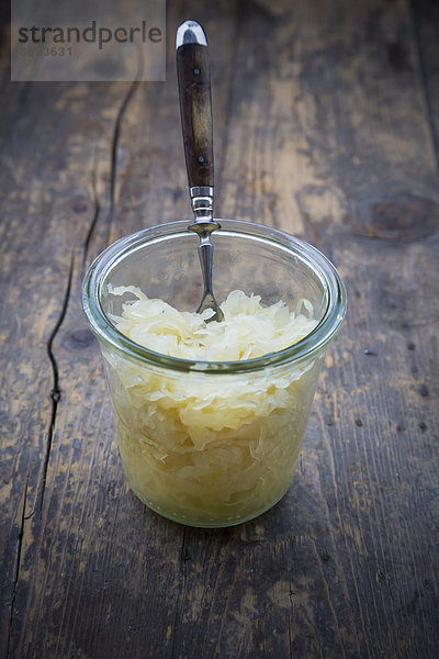 Einmachglas mit Sauerkraut auf Holztisch