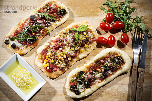 Pizzabrötchen  mit Schinken  Salami  Mozzarella  Tomaten  Rucola  Mais und Oliven
