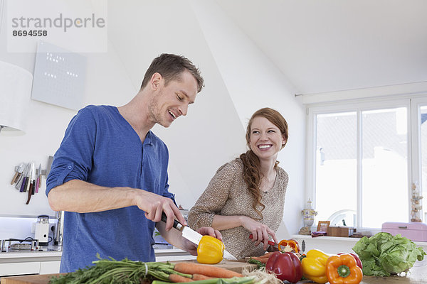 Junges Paar bei der Zubereitung von Speisen in der Küche