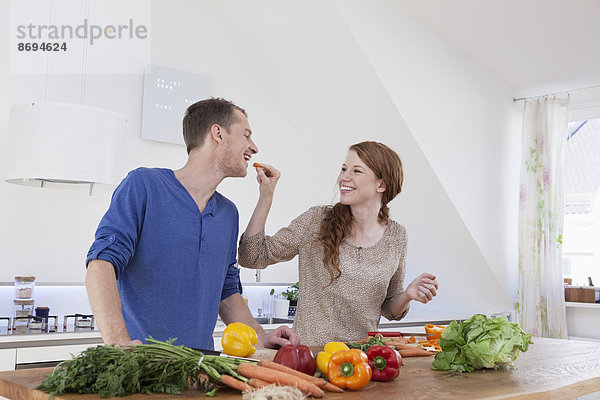 Junges Paar bei der Zubereitung von Speisen in der Küche