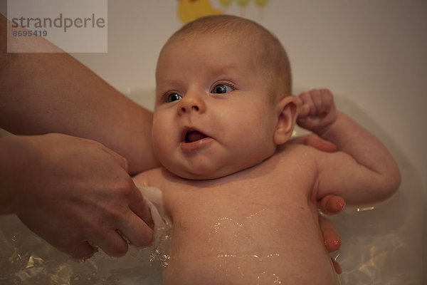Baby  Mädchen  2 Monate  beim Baden in einer Babybadewanne