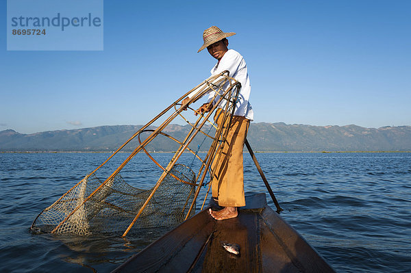 Fischer mit traditionellem Korb  gefangener Fisch im Kanu  Inle-See  Shan-Staat  Myanmar