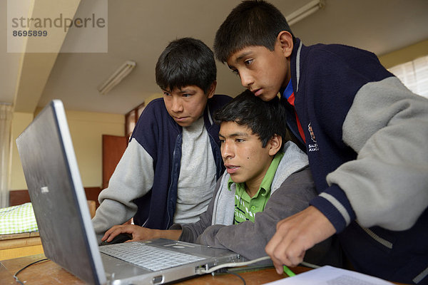 Drei Jungen in einem Kinderheim arbeiten gemeinsam am Laptop  Ayacucho  Region Ayacucho  Peru