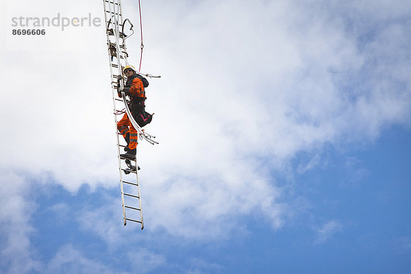 Freileitungsmonteur bei Leiterseilzugarbeiten auf der Traverse eines neu errichteten Höchstspannungsmastes  Mönchenholzhausen  Thüringen  Deutschland