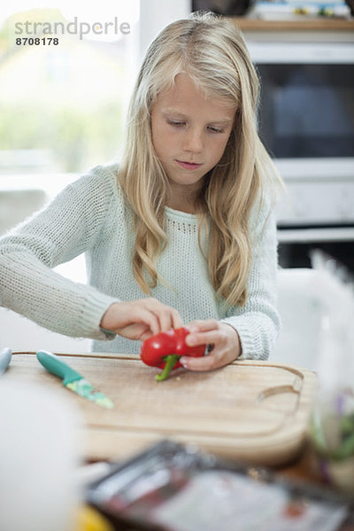 Mädchen schneiden Paprika in der Küche