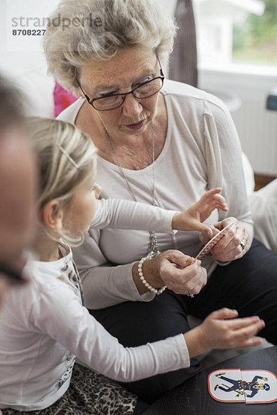 Großmutter und Enkelin beim Kartenpuzzlespiel zu Hause