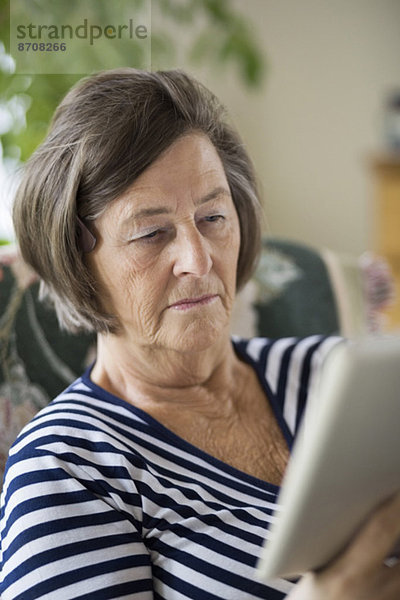 Seniorin mit digitalem Tablett zu Hause