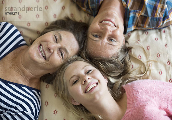 Overhead-Porträt von glücklichen Drei-Generationen-Weibchen auf dem Bett liegend