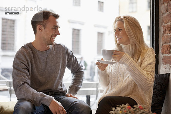 Glückliches junges Paar verbringt seine Freizeit im Cafe