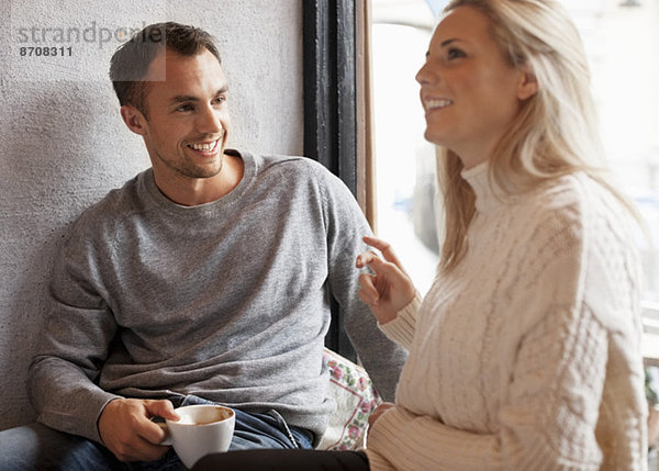 Ein glückliches junges Paar verbringt seine Zeit im Café.