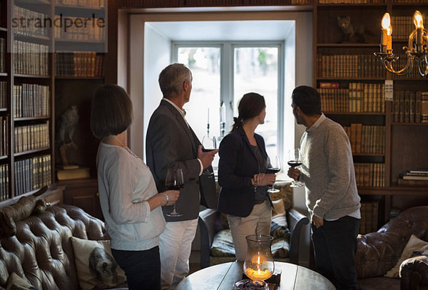 Geschäftsleute mit Weingläsern blicken in die Lobby des Restaurants