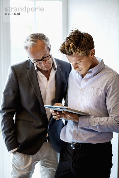 Geschäftsleute mit digitalem Tablett im Büro