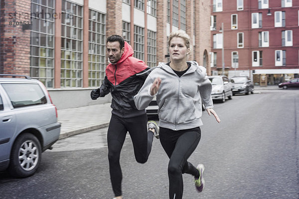 Sportliches Paar beim Laufen auf der Straße
