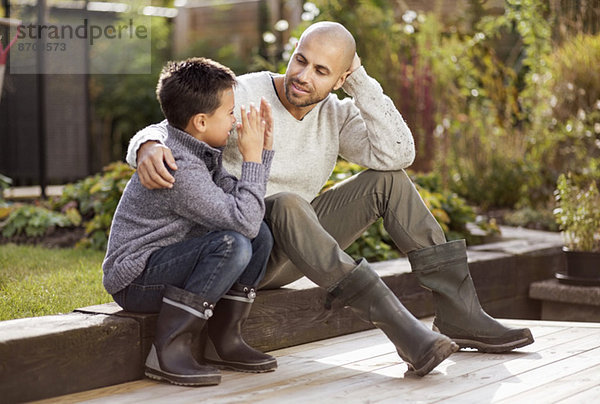 Vater und Sohn sitzen im Garten