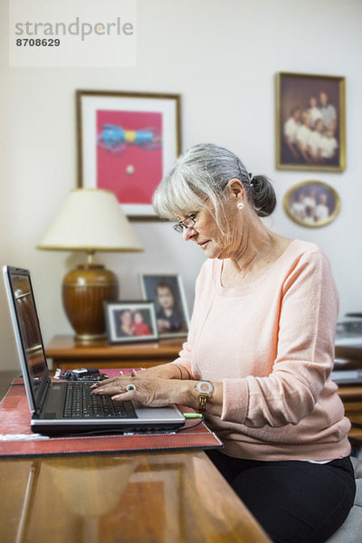 Senior Frau mit Laptop zu Hause