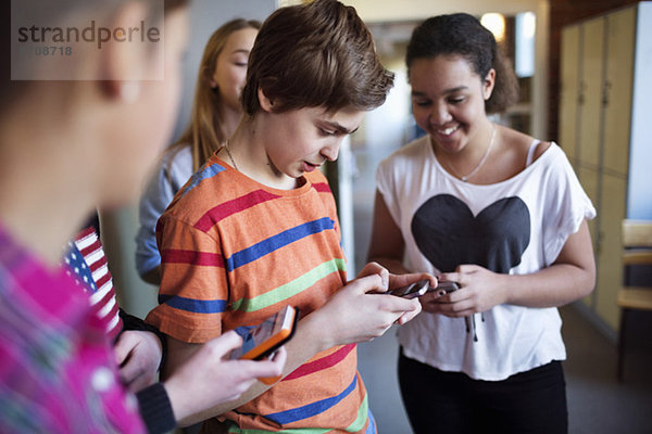 Schüler  die Mobiltelefone in der Umkleidekabine der Oberschule benutzen