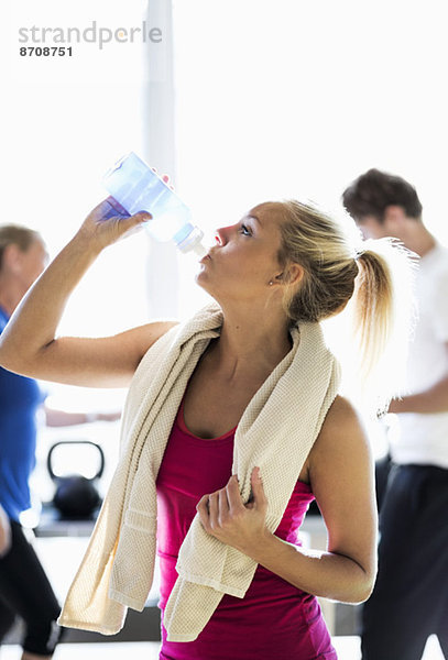 Fit junge Frau Trinkwasser im Fitnessstudio