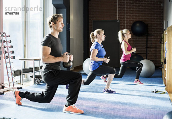 Kunden trainieren mit Kettlebells im Fitnessstudio