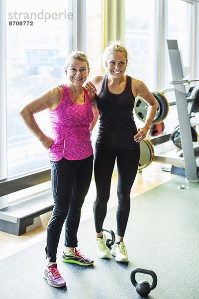 Ganzkörperporträt glücklicher Frauen im Fitnessstudio