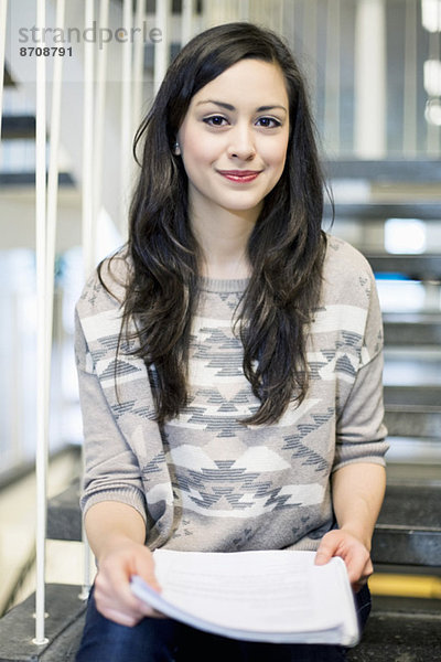 Porträt einer selbstbewussten Studentin auf der Treppe der Universität