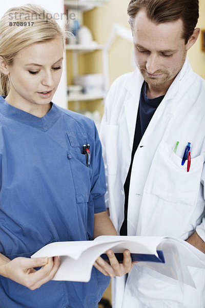 Arzt und Krankenschwester lesen Akte im Krankenhaus