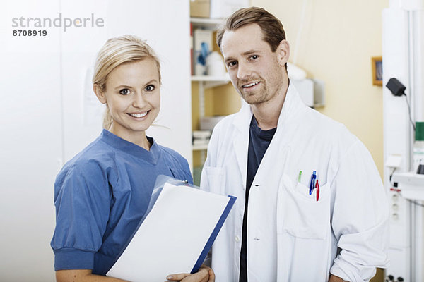 Porträt des selbstbewussten Arztes und der Krankenschwester mit Akte im Krankenhaus