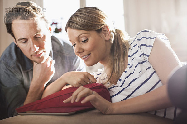 Mittleres erwachsenes Paar mit digitalem Tablett im Haus