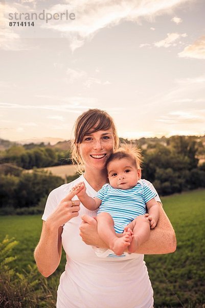 Porträt eines kleinen Mädchens  das den Finger der Mutter greift