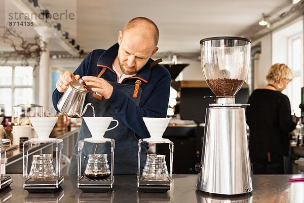 Barista gießt kochendes Wasser in Kaffeefilter