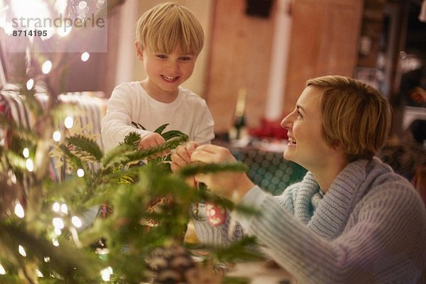 Mutter und Sohn schmücken den Weihnachtsbaum