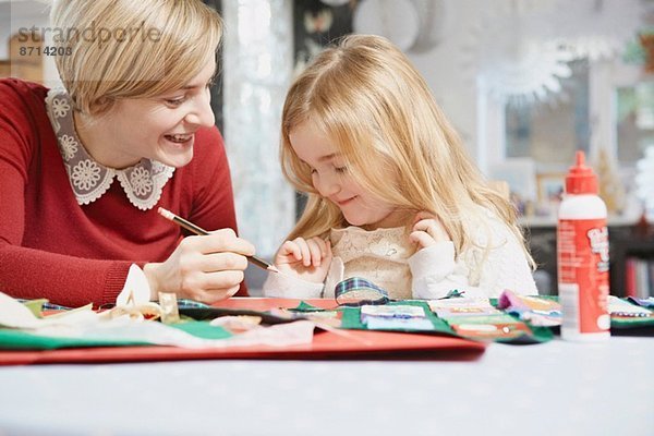 Mutter und Tochter zeichnen am Küchentisch