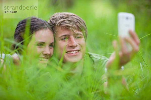 Junges Paar selbst fotografiert auf Gras