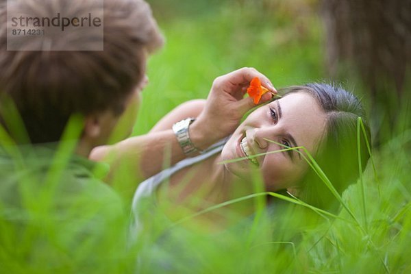 Junger Mann mit Blume im Haar der Frau